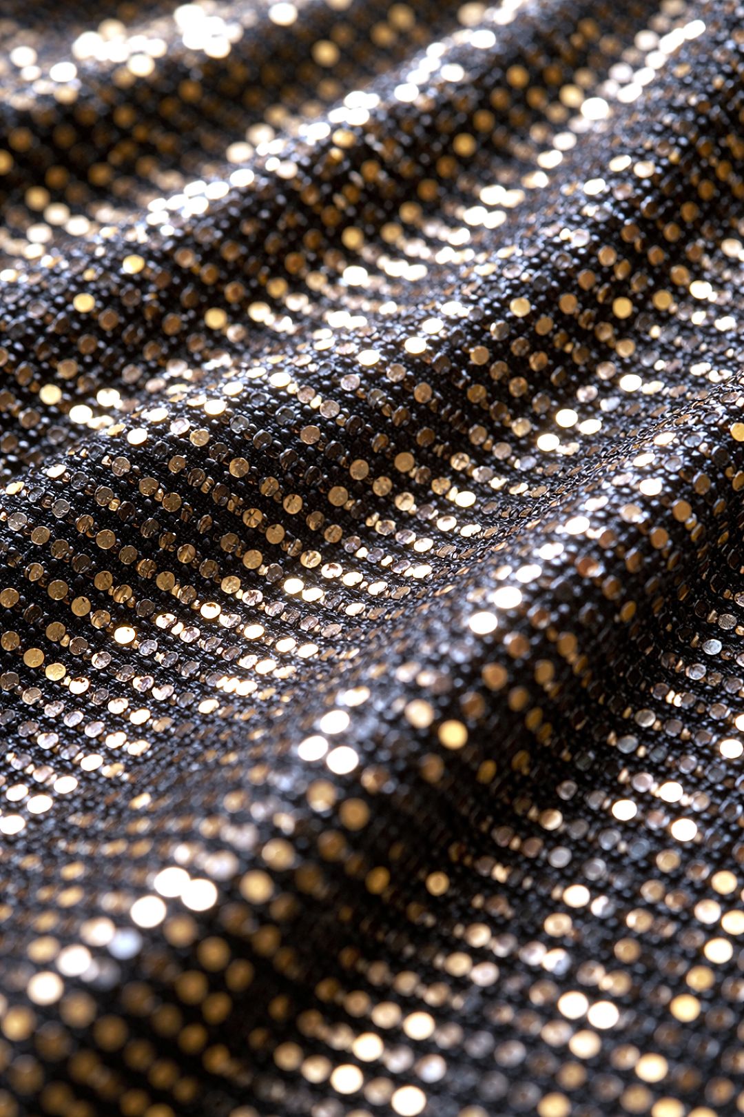 Close-up of FlexyDrip liquid gold co-ord set fabric with a pattern of small sequins.