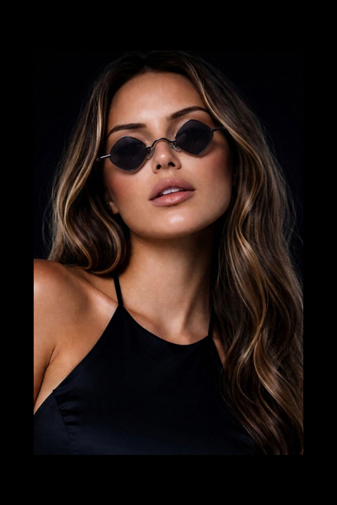 Woman wearing Flexydrip eclipse micro black sunglasses against a dark background